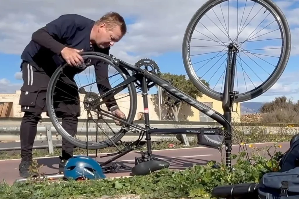 Graham Caldow repairing a puncture in the back wheel of bicycle